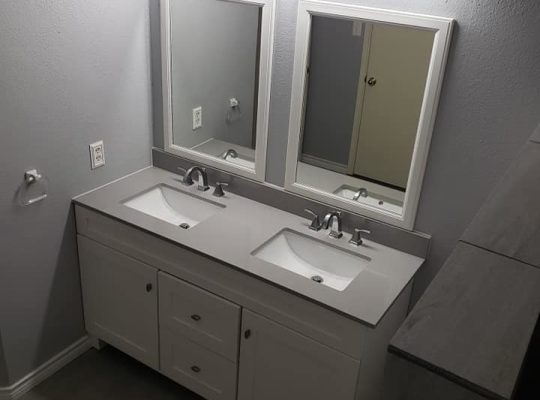 An elegant bathroom with dual sinks and a reflective mirror.