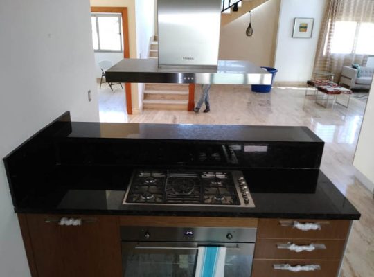 A kitchen with a stove top and a sink.