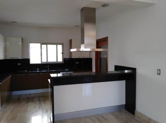 Kitchen with black and white countertops, stainless steel appliances, and wooden cabinets.
