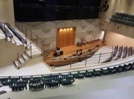 An unoccupied theatre stage with no decorations or cast members.