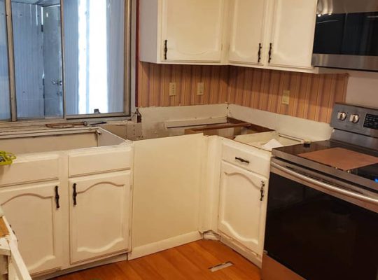 Kitchen with stove, sink, and cabinets.