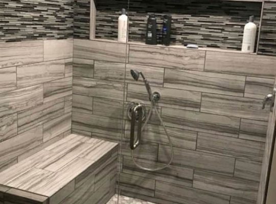 A bathroom with a large walk-in shower and a toilet.